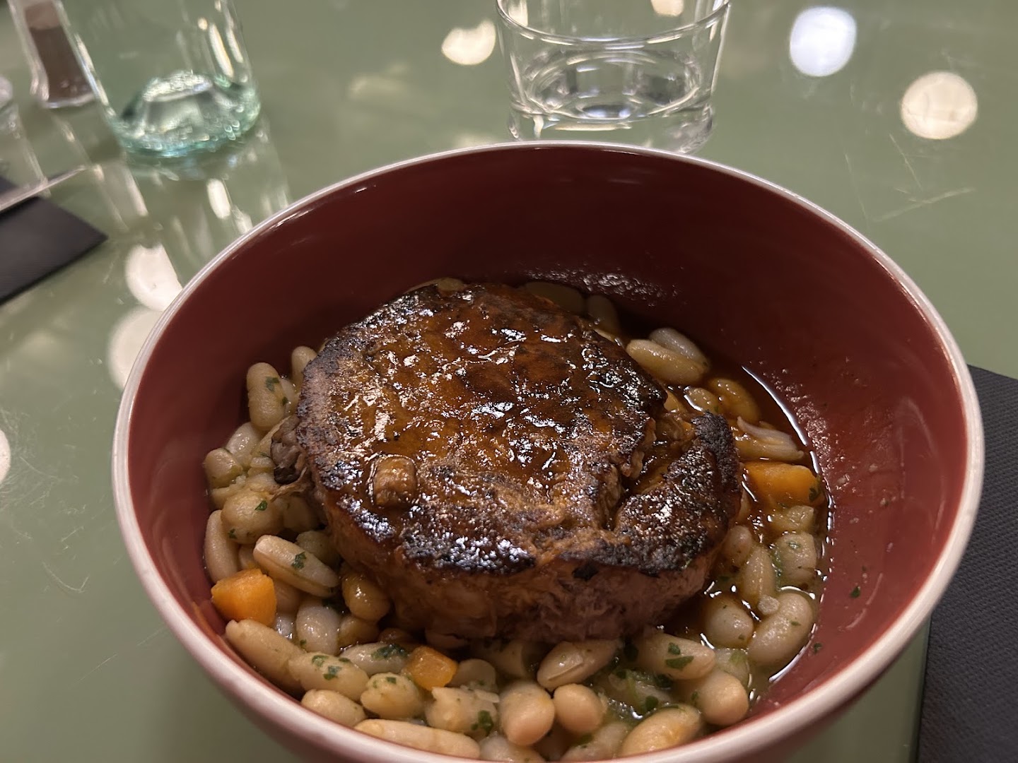 Une viande mijotée servie avec des haricots et des légumes