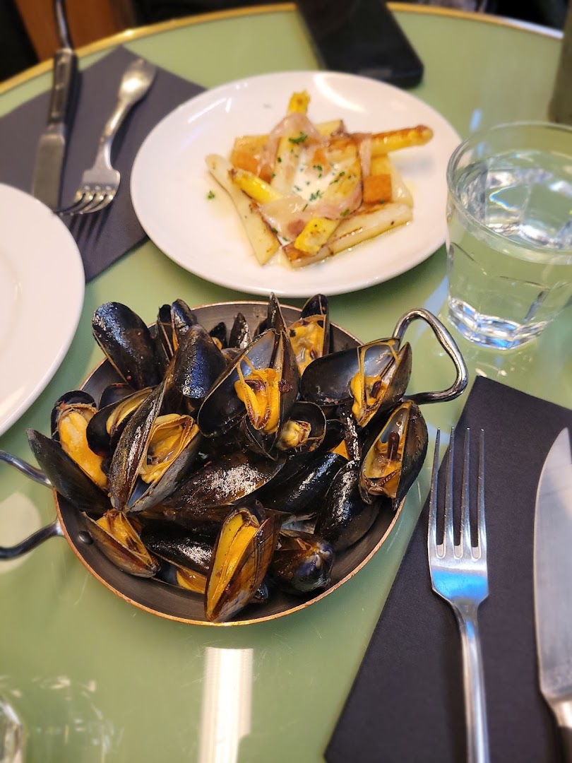 Une casserole de moules servie sur une table verte
